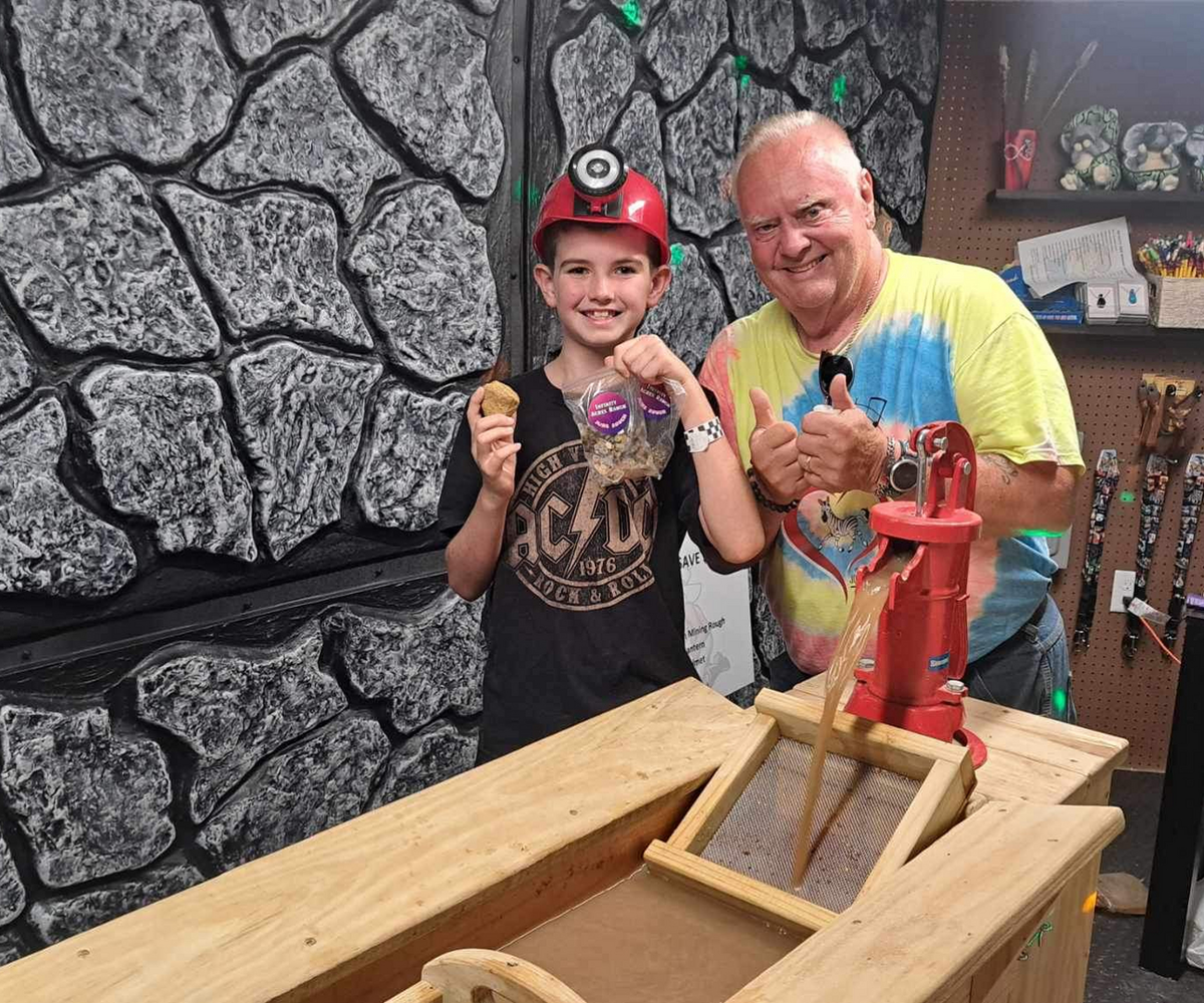 Child and adult posing with mining gear