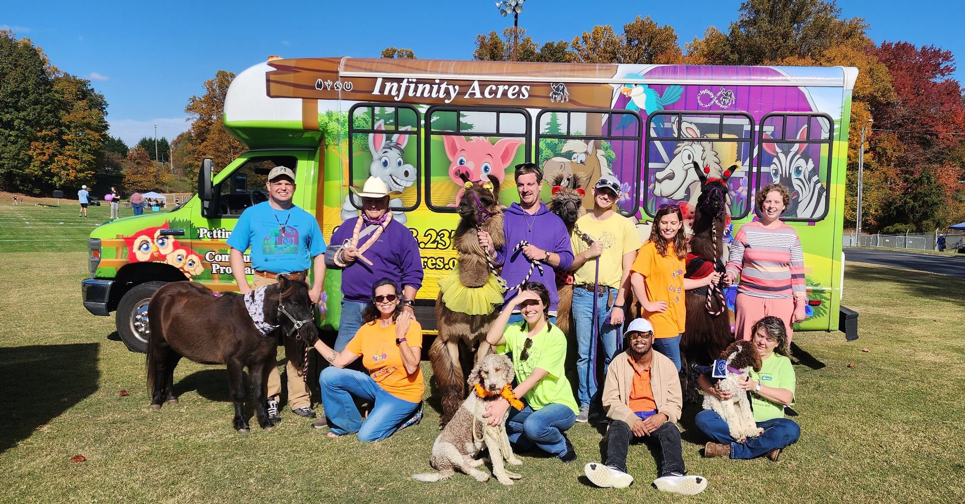 Group with animals in front of colorful bus