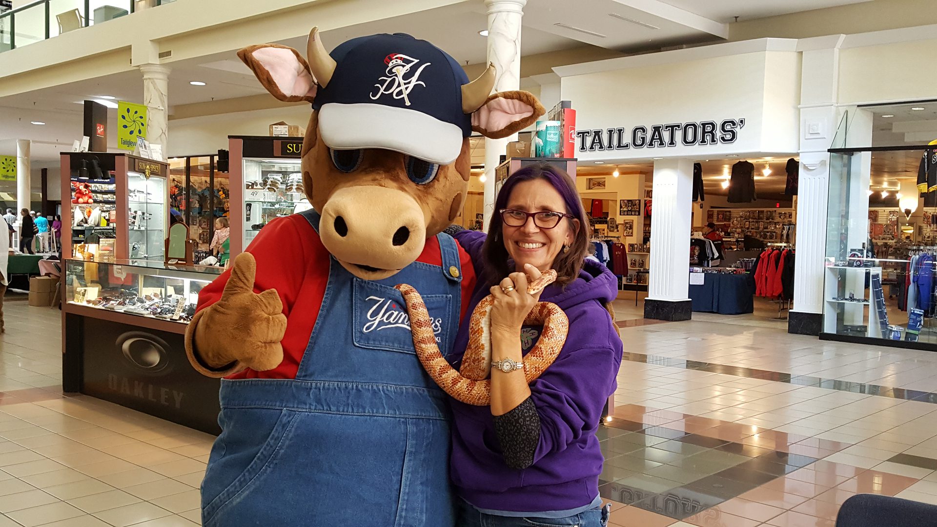 Woman posing with mascot and snake