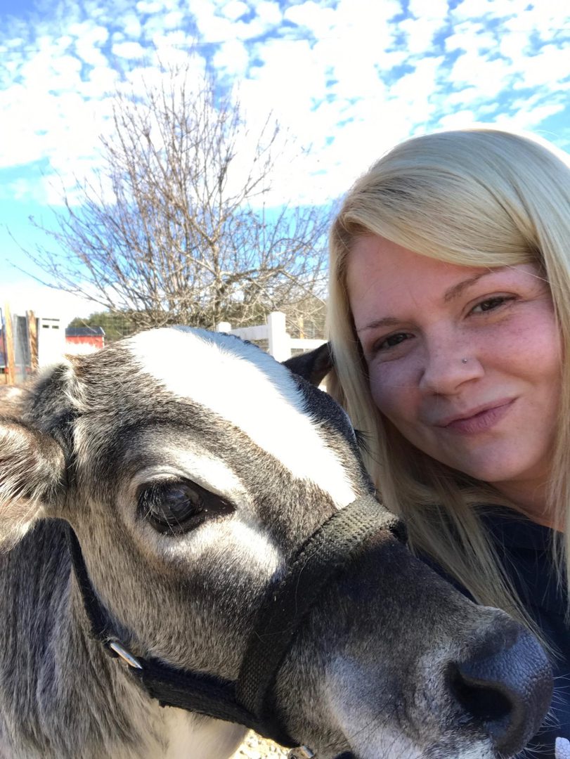 Woman smiling with a calf