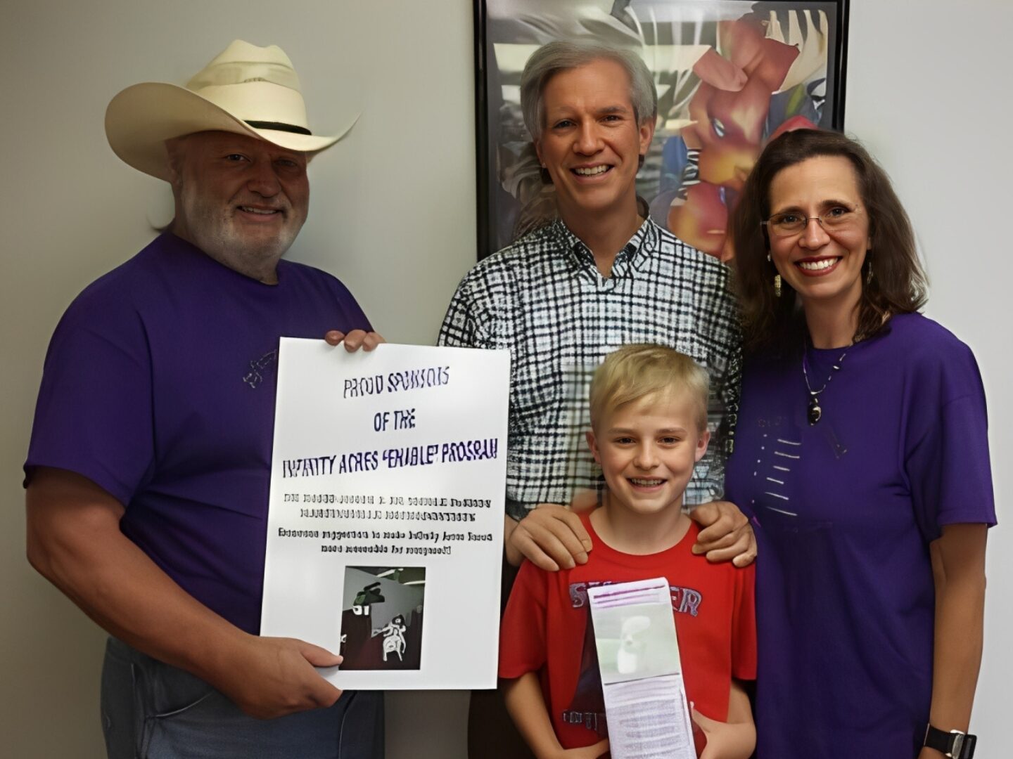 Smiling family with sponsorship poster