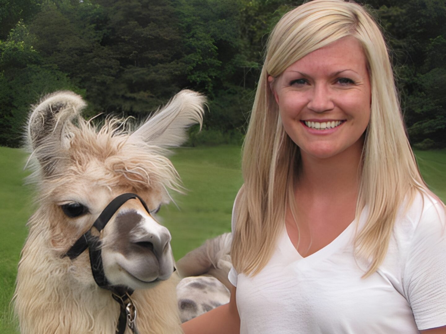 Smiling woman with a llama outdoors