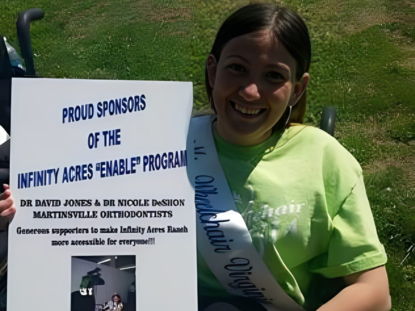 Woman holding sponsor sign outdoors