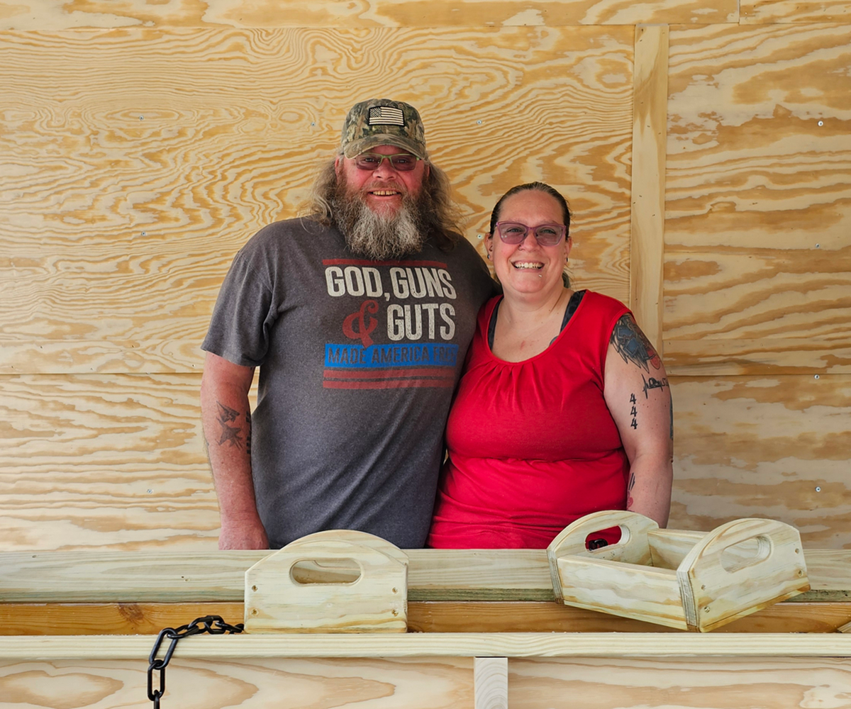 Smiling couple in front of wooden wall