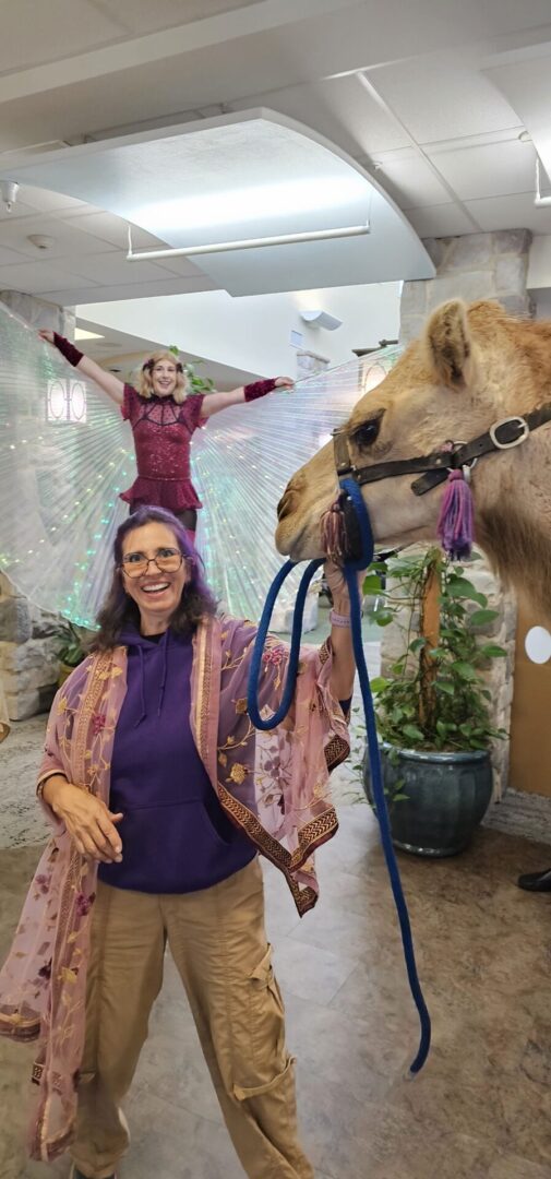 A joyful woman posing with a llama indoors.