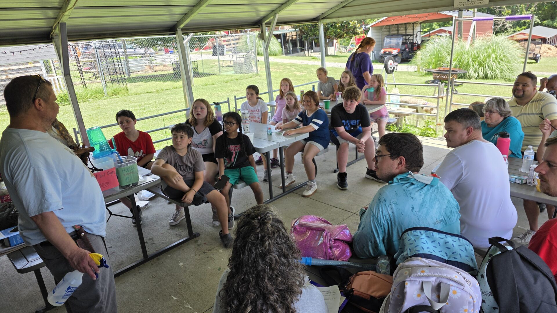 A group of young people gathered under a pavilion in a park.