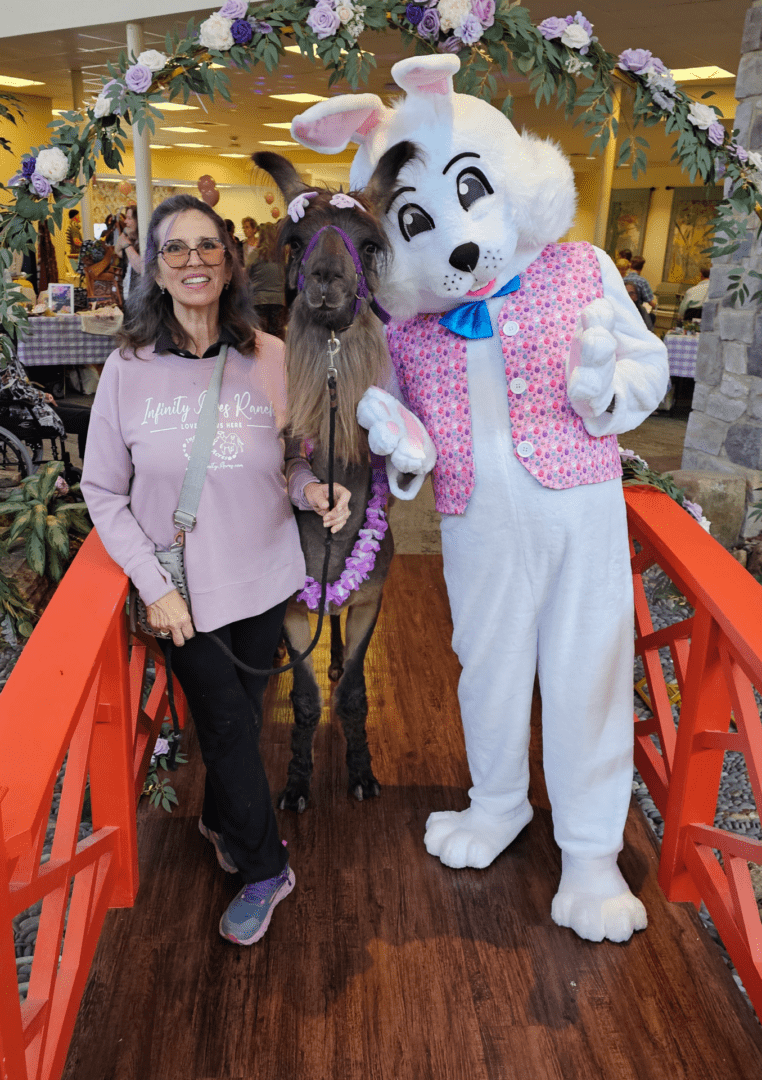 Woman with a dog posing next to a person in a bunny costume.